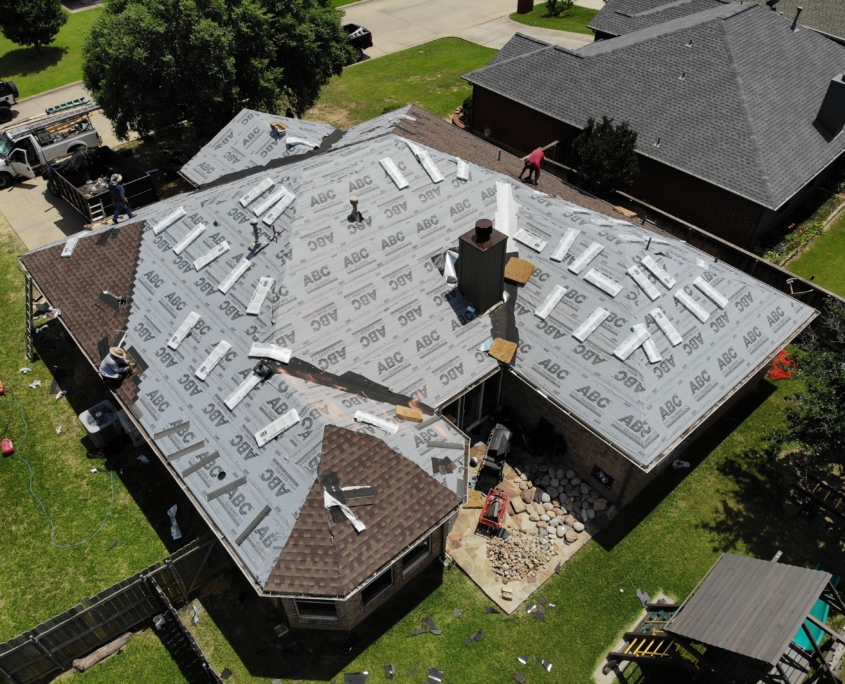 Aerial view of a residential roofing project with materials and workers on site.